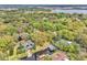 Gorgeous aerial view featuring a waterfront property with private dock, solar panels and surrounded by lush greenery at 5374 Crooked Oak Cir, St Cloud, FL 34771