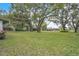 Expansive backyard featuring mature trees offering ample shade, and lush green grass, perfect for outdoor enjoyment at 5374 Crooked Oak Cir, St Cloud, FL 34771