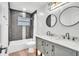 Modern bathroom featuring a double vanity with marble countertop, dark fixtures, and hexagon tile in the shower at 5374 Crooked Oak Cir, St Cloud, FL 34771