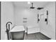 Sleek bathroom featuring a black soaking tub, rain shower, herringbone floor tiles, and a marble tiled bench at 5374 Crooked Oak Cir, St Cloud, FL 34771