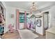 Bright bedroom featuring a unique playhouse bed, soft pink curtains, wood floors, and a decorative chandelier at 5374 Crooked Oak Cir, St Cloud, FL 34771
