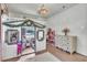 Playful bedroom with a whimsical playhouse bed, adorned with greenery and complemented by wood flooring and a chandelier at 5374 Crooked Oak Cir, St Cloud, FL 34771
