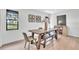 Dining room features a farmhouse table with a bench, natural light, and minimalist decor at 5374 Crooked Oak Cir, St Cloud, FL 34771