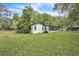 Rear view of the home with large, screened windows and lush landscaping at 5374 Crooked Oak Cir, St Cloud, FL 34771