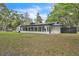 Rear exterior featuring large screened windows and a well-manicured lawn at 5374 Crooked Oak Cir, St Cloud, FL 34771