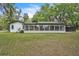 Rear view of the home showcasing the large screened windows and expansive backyard at 5374 Crooked Oak Cir, St Cloud, FL 34771