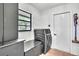 Well-lit laundry room with modern washer and dryer, storage cabinets, and a convenient folding surface at 5374 Crooked Oak Cir, St Cloud, FL 34771