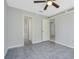 Spacious bedroom with ceiling fan, tile floors and multiple doorways at 6050 Scotchwood Gln # Ge, Orlando, FL 32822