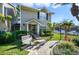 A view of the townhome with a charming front porch, lush landscaping, and paved walkway at 6050 Scotchwood Gln # Ge, Orlando, FL 32822