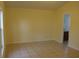 Spacious bedroom with tile floor, light yellow walls, and an open doorway at 6321 Redwood Oaks Dr, Orlando, FL 32818