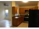 Well-lit kitchen featuring wood cabinets, tile floor, and stainless steel stove at 6321 Redwood Oaks Dr, Orlando, FL 32818