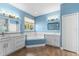 Bright bathroom featuring dual vanities, tile floors, and a soaking tub under a window at 6854 Remington View Ct, Orlando, FL 32829