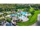 Aerial view of a community pool area featuring multiple pools, waterslides, and lush landscaping at 6854 Remington View Ct, Orlando, FL 32829