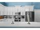 Well-lit kitchen with stainless steel appliances, white cabinets, mosaic backsplash, and a center island with quartz countertop at 6854 Remington View Ct, Orlando, FL 32829