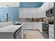 Bright kitchen with white cabinets, stainless steel appliances, quartz counters, mosaic tile backsplash, and wood-look flooring at 6854 Remington View Ct, Orlando, FL 32829