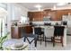 View of open kitchen, featuring granite countertops, stainless appliances, and a center island with seating at 7407 Ripplepointe Way, Windermere, FL 34786