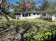 Backyard view of a home with mature trees, lush lawn, and landscaping that offers a peaceful retreat at 818 Logan Dr, Longwood, FL 32750