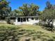 Backyard view features a lush lawn, screened porch, and mature landscaping, perfect for outdoor enjoyment at 818 Logan Dr, Longwood, FL 32750