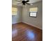 Bedroom with wood-look flooring, ceiling fan, and natural light from two windows with blinds at 818 Logan Dr, Longwood, FL 32750