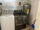 Laundry room featuring a washer, dryer, and water heater, along with shelving for storage at 818 Logan Dr, Longwood, FL 32750