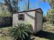 Exterior view of a storage shed with red trim; a functional addition for yard equipment and storage at 818 Logan Dr, Longwood, FL 32750