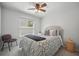 Comfortable bedroom with neutral tones, ceiling fan, and large window at 872 High Pointe Cir, Minneola, FL 34715