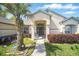 Charming home featuring a covered front entrance, lush landscaping, and a well-manicured lawn at 872 High Pointe Cir, Minneola, FL 34715