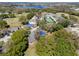 Scenic aerial view of a home in a community near a golf course and lake at 8722 Village Green Blvd, Clermont, FL 34711