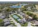 Beautiful aerial view of the neighborhood showcasing lakes, a pool, and tennis court at 8722 Village Green Blvd, Clermont, FL 34711