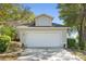 Charming home featuring a two-car garage and a well-maintained front yard, enhancing its curb appeal at 8722 Village Green Blvd, Clermont, FL 34711