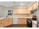 Bright kitchen with white countertops, light wood cabinets, and stainless steel appliances at 8722 Village Green Blvd, Clermont, FL 34711