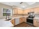 Kitchen featuring light wood cabinets, quartz counters, stainless appliances and wood floors at 8722 Village Green Blvd, Clermont, FL 34711