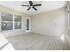 Enclosed patio features neutral paint, ceiling fan, and tile flooring at 8722 Village Green Blvd, Clermont, FL 34711