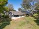 Exterior back view of home showcasing yard and screened-in porch at 8722 Village Green Blvd, Clermont, FL 34711