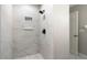 Elegant tiled shower with built-in niche and modern fixtures at 8722 Village Green Blvd, Clermont, FL 34711