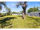 This backyard has a large grassy area, mature trees, and a storage shed at 9744 Cub Cv, Apopka, FL 32703