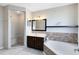 Bathroom featuring vanity with double sinks, bathtub with colorful tile accents, and walk-in shower with bench at 9744 Cub Cv, Apopka, FL 32703