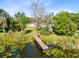 Wooden dock on a tranquil lake with lily pads, providing access to the waterfront home at 9744 Cub Cv, Apopka, FL 32703