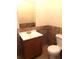 Tiled bathroom with a wooden vanity and a standard toilet at 100 John St, Frostproof, FL 33843
