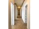 Long hallway with neutral walls and tile flooring, leading to multiple rooms at 100 John St, Frostproof, FL 33843