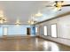 Open interior space featuring tile flooring, ceiling fans, and multiple doors at 100 John St, Frostproof, FL 33843
