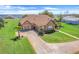 Aerial view of the home with a three car garage, nice landscaping and brick driveway at 10544 Spring Lake Dr, Clermont, FL 34711