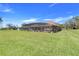 A spacious backyard with a screened-in pool and well-manicured lawn at 10544 Spring Lake Dr, Clermont, FL 34711