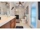 Bright bathroom features tile floor, glass shower door, vanity, toilet and doorway to exterior at 10544 Spring Lake Dr, Clermont, FL 34711