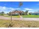 Beautifully landscaped home with a brick driveway and a well-manicured lawn at 10544 Spring Lake Dr, Clermont, FL 34711