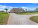 Charming home featuring a three-car garage, brick driveway and lush landscaping at 10544 Spring Lake Dr, Clermont, FL 34711