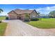 Charming home featuring a three-car garage, brick driveway and lush landscaping at 10544 Spring Lake Dr, Clermont, FL 34711
