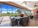Covered outdoor dining area boasts a stylish table and chairs, with views of the pool and lush landscaping at 10544 Spring Lake Dr, Clermont, FL 34711