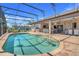 Beautiful pool area with a screened enclosure, ample seating, and serene views of the surrounding landscape at 10544 Spring Lake Dr, Clermont, FL 34711