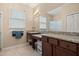 Bathroom featuring dual sinks, granite counters, and a large mirror, offering both style and functionality at 10942 High Bush Ct, Orlando, FL 32825